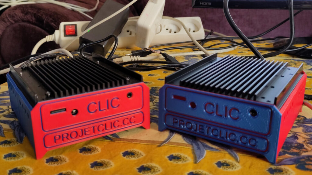 Deux boîtiers imprimés en 3D, un rouge et un bleu, indiquant le nom et l'url du projet CLIC.