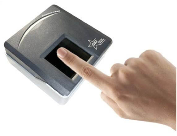 l'index d'une main est posé sur un boîtier qui scanne les empreintes digitales
